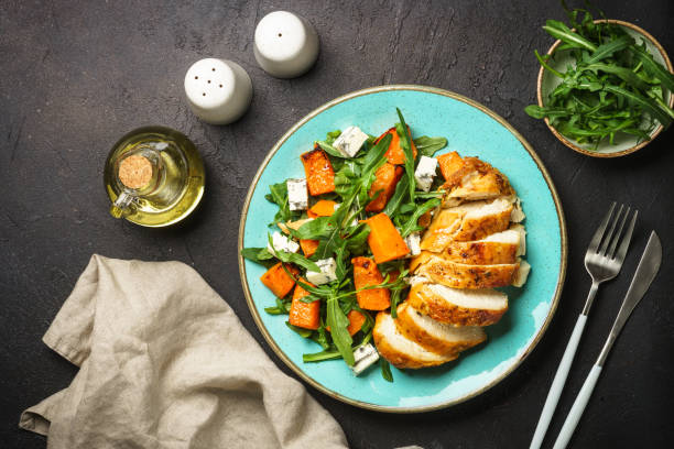 istock Chicken salad with pumpkin and arugula at black. 1644267944