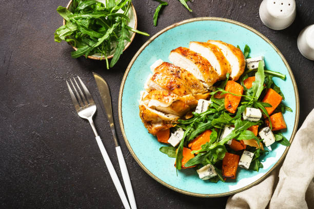 istock Chicken salad with pumpkin and arugula at black. 1644272465