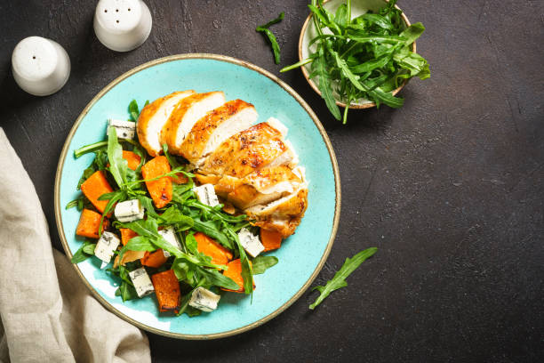 istock Chicken salad with pumpkin and arugula at black. 1644272467