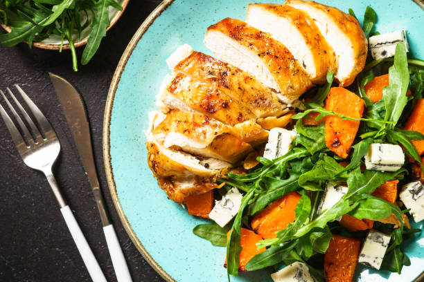 istock Chicken salad with pumpkin and arugula at black. 1644273682