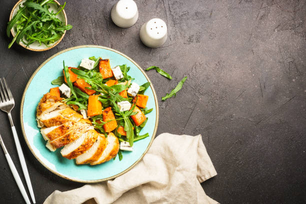 istock Chicken salad with pumpkin and arugula at black. 1644275320