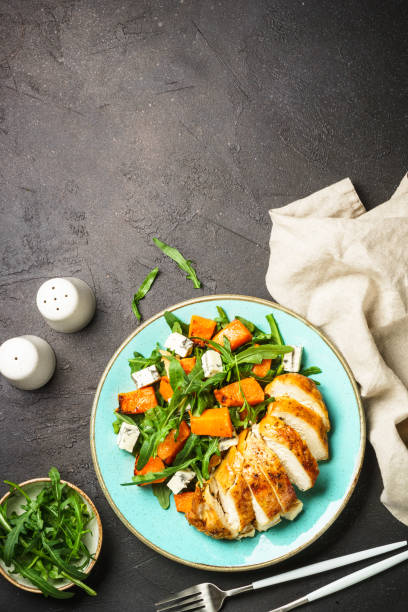 istock Chicken salad with pumpkin and arugula at black. 1644275860