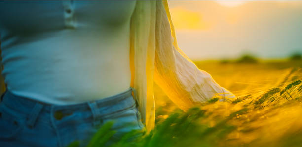 istock Young woman touching crops in field at sunset 1644286003