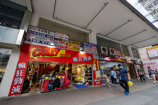 Hong Kong - August 28, 2023 : Pedestrians walk past the Nathan Road in Yau Ma Tei, Kowloon, Hong Kong.