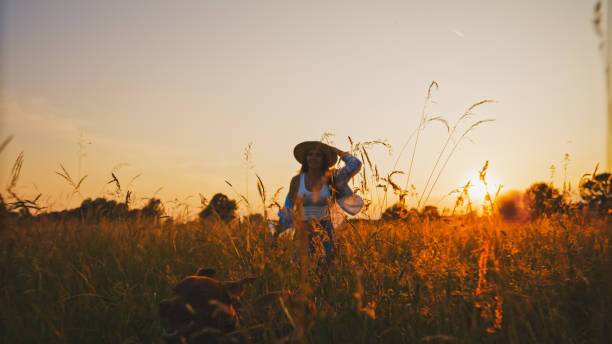 istock Woman exploring field with pet dog during sunset 1644289865