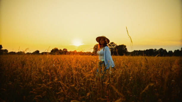 istock Young woman walking amidst crops and exploring field 1644289867