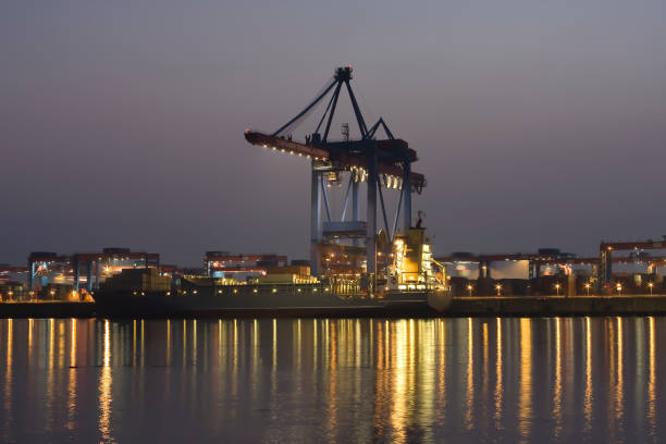 containererschip is charged at dusk, at container terminal altenwerder, hamburg harbor, germany - hafen containerterminal imagens e fotografias de stock