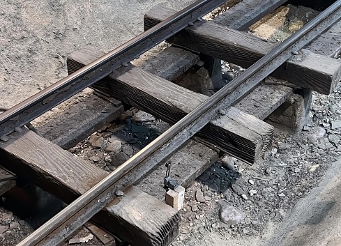 a photography of a train track with a broken rail, lumbermill railroad tracks with a broken rail and a broken rail.