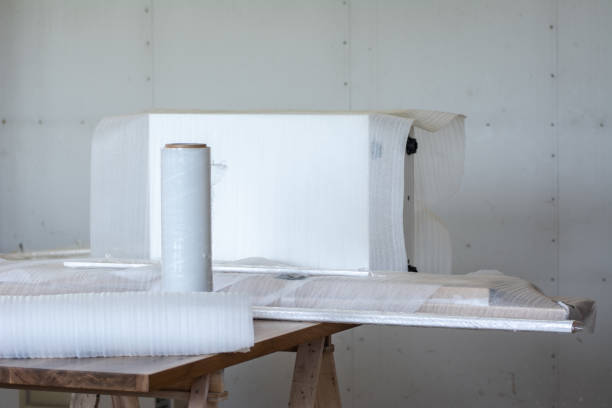 istock Packing carpentry products in white protective film in a small workshop 1644312737