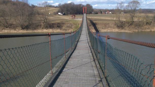 istock Old Wooden Suspension Footbridge on a River 1644322631