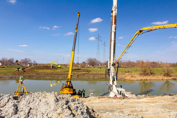 istock Mobile crane and truck pump pouring fresh concrete into bridge foundation 1644330152