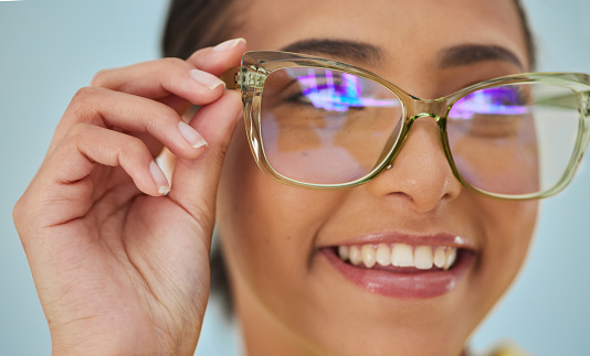 Woman, glasses and vision with blue light frame with a smile with ophthalmology. Isolated, studio background and happy person with eye care, wellness and health of a girl with eyewear and healthcare