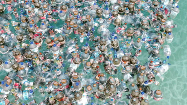 Oceanic Heap of Plastic Bottles Spotlights Environmental Dilemma Different kinds of plastic bottles and plastic containers are laying in a big pile in the sea. Concept of plastic waste and environmental issues. plastic marine life stock pictures, royalty-free photos & images