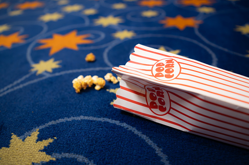 Popcorn and film strip on the blue background.