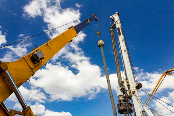 istock Mobile crane and drilling machine working together on bridge foundation 1644347769
