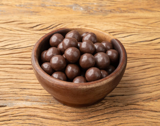 istock Chocolate malted balls in a bowl over wooden table 1644350457