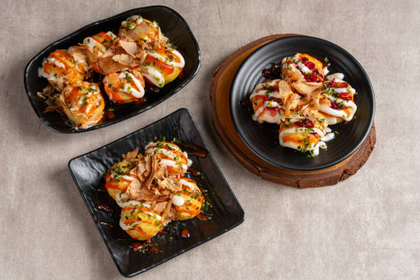 Takoyaki Takoyaki is a ball-shaped Japanese snack made of a wheat flour-based batter and cooked in a special molded pan cooking takoyaki is a ball shaped japanese snack stock pictures, royalty-free photos & images