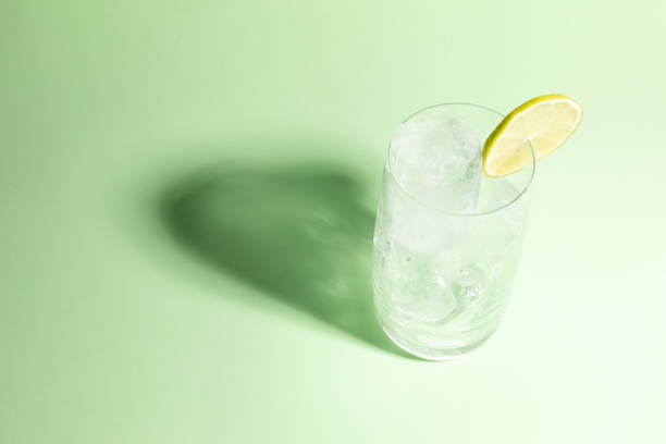 istock Cold glass full of ice with a lime, ready to serve light green with cast shadow. 1644395105