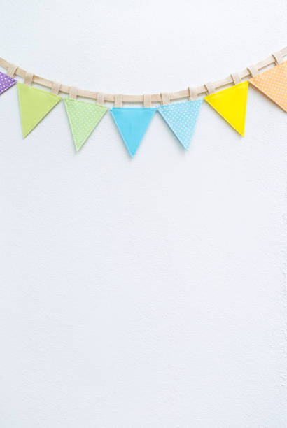 istock Fabric colorful bunting flag with space on white cement wall background, vertical style 1644395114