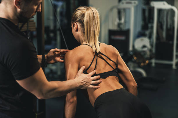 istock Woman Doing Hard Training For Back Muscle With Coach At The Gym 1644402186
