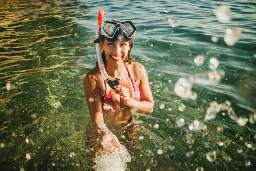 An attractive woman with her scuba mask and snorkel having fun and enjoy on the beach time.