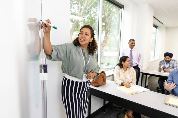 istock Female lecturer teaches while adult students hold discussion 1644406565