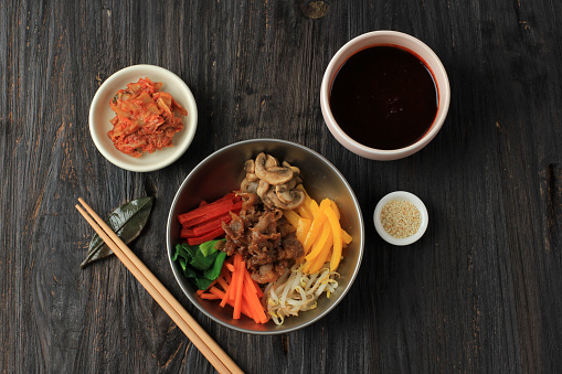 Top View Bibimbap Korean Mixed Rice. Rice Topped with Seasoned Vegetables, Meat, Mushroom, Add Spicy Chili Sauce