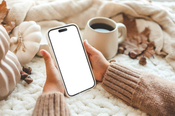 istock Phone with an isolated screen in hands, autumn mood 1644414615