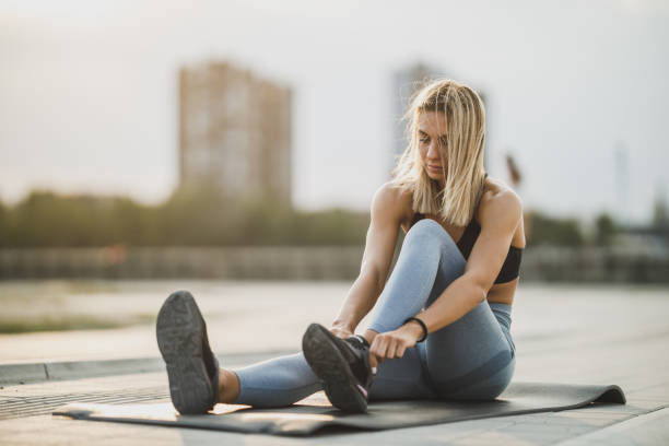 istock Woman Tying Her Shoelaces While Out For A Run 1644424086
