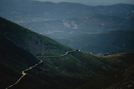 Winding serpentine road on a green slope in the foothills of Serra da Estrela, Portugal.