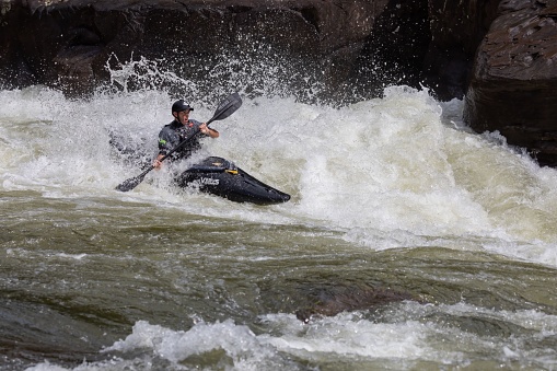 Summersville, United States – September 30, 2020: An adventurous kayaker paddling through the rough rapids on the Gauley River in West Virginia