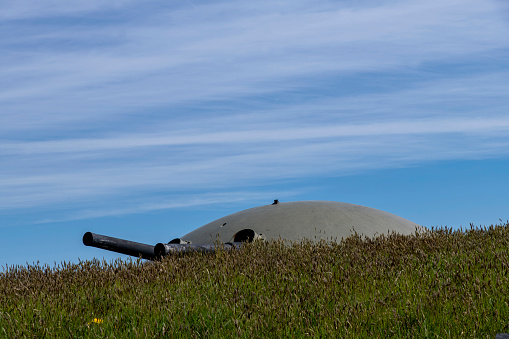 Westbeemster, The Netherlands-April 2022; Low angle close up view of revolving turret gun on Fort Spijkerboor just above grassy hill; most important fort in Amsterdam defence line (or stelling)