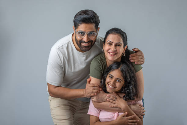 istock Smiling parents with daughter posing on white background 1644451210