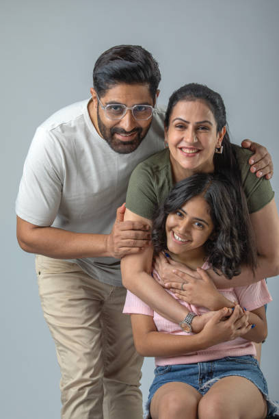 istock Smiling parents with daughter posing on white background 1644451725