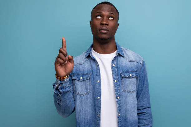 istock handsome young attractive african man dressed casually in denim clothes actively gesturing with his hands pointing at an idea 1644458051