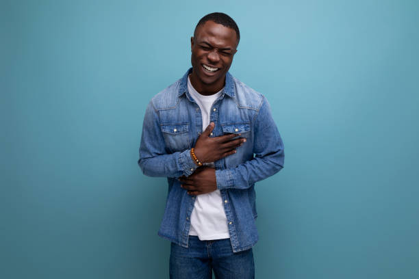 istock young african guy in denim jacket holding his stomach 1644458588