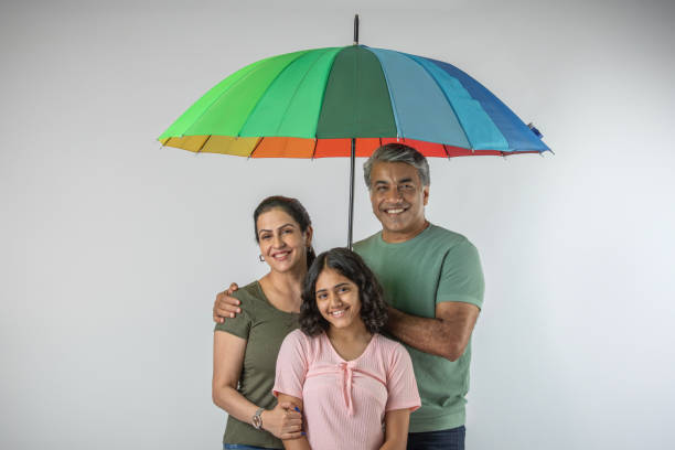 istock Parents and daughter with umbrella against white background 1644459962