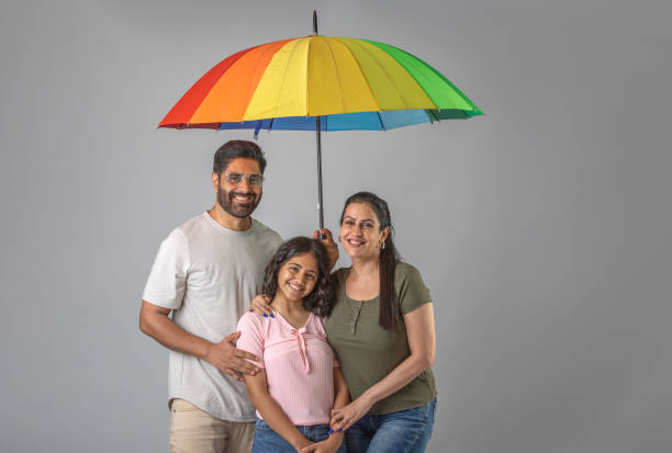 istock Parents and daughter with umbrella against white background 1644460244
