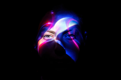 Colorful lights on woman's face.