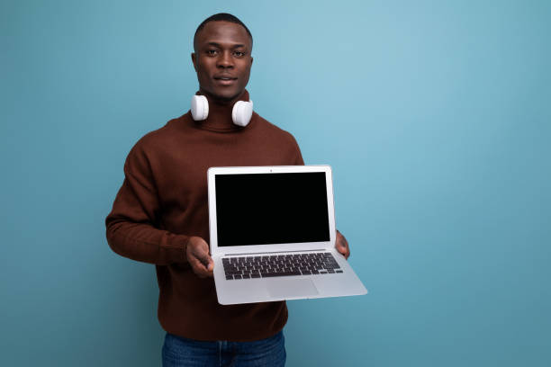 istock technology store consultant. African man holding a working laptop in his hands 1644468530