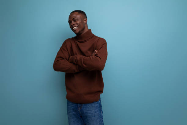 istock dark-skinned 25 year old guy with a short haircut in a brown sweater laughs on a studio background with copy space 1644468576