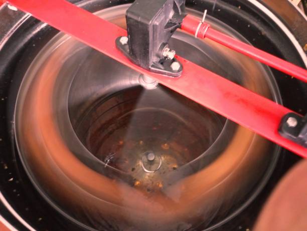 istock The process of pumping honey out of the frames using a hand-held honey-pumping machine. 1644469736