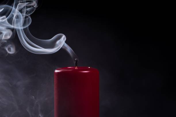 istock Burnt out red candle emitting white smoke on a dark background 1644474360