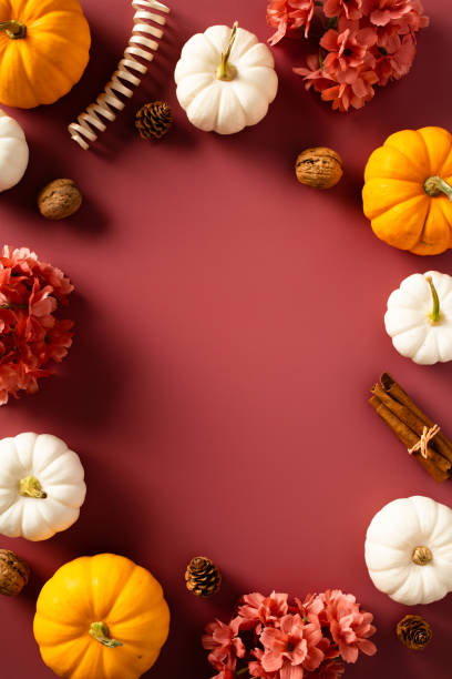 istock Autumn, fall vertical banner design with ripe pumpkins, flowers, cinnamon sticks, walnuts, pine cones on dark red background. 1644482253