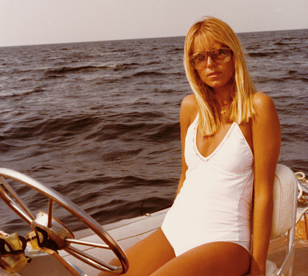 Young woman wearing swimwear on inflatable raft in 1968.