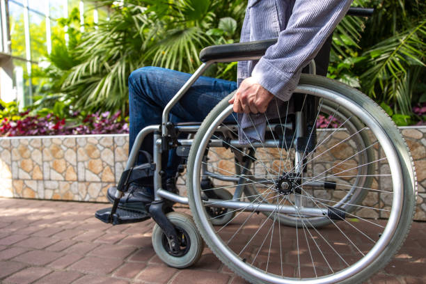 istock Gray-haired man on a wheelchair in a park 1644485121