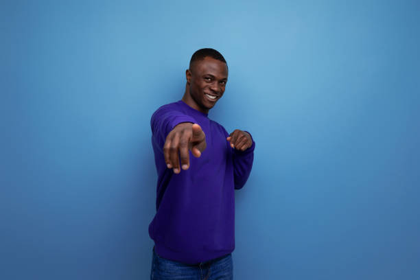 istock charming cute young african guy in a blue sweatshirt on the background with copy space 1644486883
