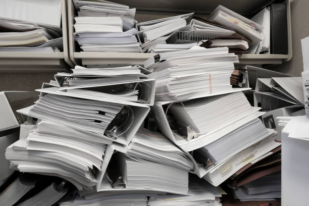 istock Messy Office Pile of Binders with Papers Filing Disorganized Mess 1644486965