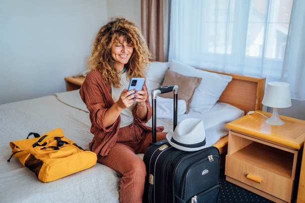 istock Woman using phone in a hotel room 1644487427