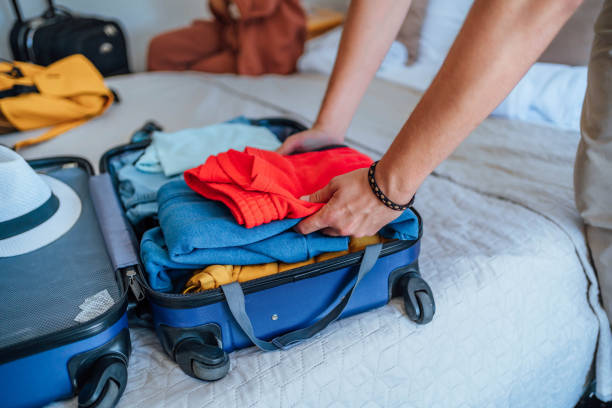istock Man unpacking luggage in a hotel room 1644487967